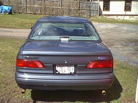 1993 Ford Taurus - Rear view of a dark blue 1992 Ford Taurus sedan parked outdoors on a grassy area.