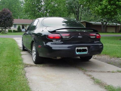 1999 Ford Taurus - Rear view of a black 1999 Ford Taurus sedan with a spoiler.