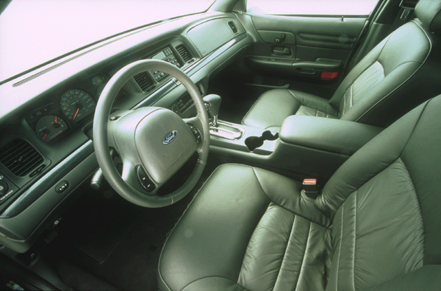 Gray leather interior of a Ford sedan with steering wheel, console shifter, and cupholders