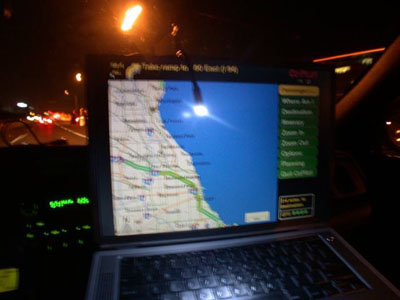 2001 Ford Crown Victoria - Laptop propped on a car's dashboard at night running mapping software, the screen showing a coastal road map with a menu of navigation comm…