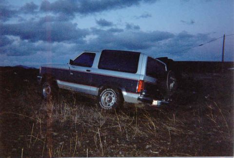1989 Ford Bronco II - A 1989 Ford Bronco II is seen from a three-quarter front angle, parked outdoors on uneven terrain.