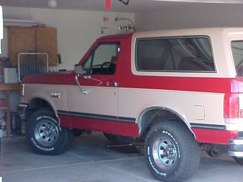 1988 Ford Bronco - This two-tone red and tan Ford Bronco is parked inside a garage.