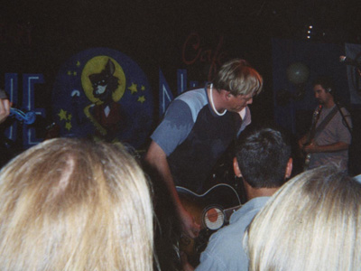 1989 Ford Bronco - A band plays music on stage in front of a backdrop a cat in a moon.