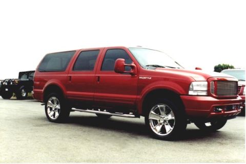 2001 Ford Excursion - A red Ford Excursion SUV is parked on asphalt, with another vehicle visible in the background.