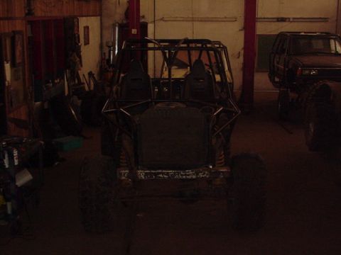 1979 Ford Bronco - A custom buggy with a prominent roll cage sits in a workshop, with another vehicle visible in the background.