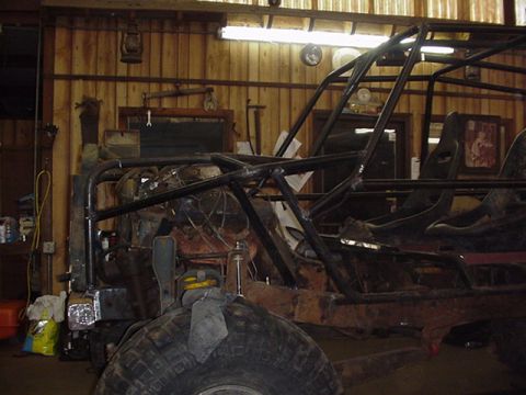1979 Ford Bronco - A custom-built buggy frame is under construction in a workshop, showing its roll cage and interior.