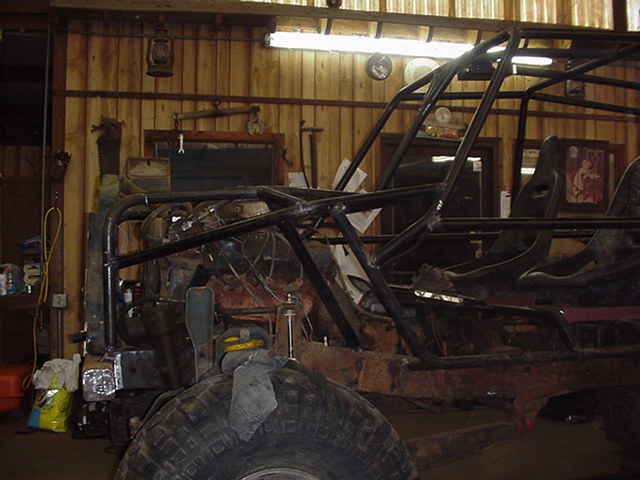 Custom buggy frame with roll cage and seats, in a workshop