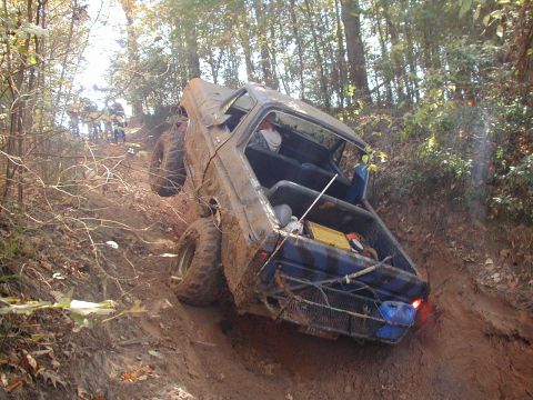 1979 Ford Bronco - This 1979 Ford Bronco navigates a challenging off-road trail, demonstrating its climbing capability on a steep, muddy incline.