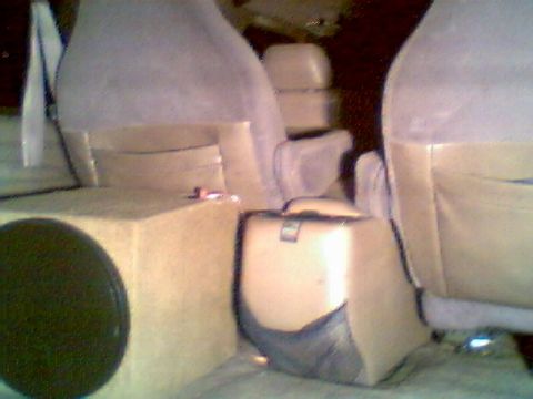 1996 Ford Bronco - The interior of a vehicle shows a custom subwoofer box and tan seats, with a watermark for Supermotors.net.