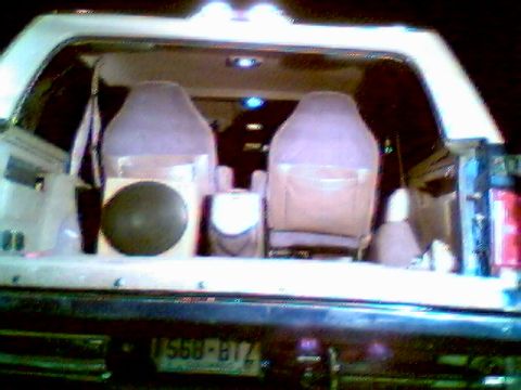 1996 Ford Bronco - The rear interior of an SUV shows two rows of seats, a speaker, and a license plate.