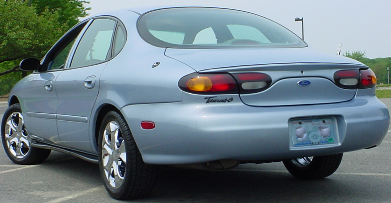 Rear view of a light blue 1998 Ford Taurus with chrome wheels
