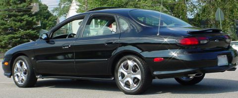 1998 Ford Taurus - This black sedan is shown from the rear quarter angle, parked outdoors.