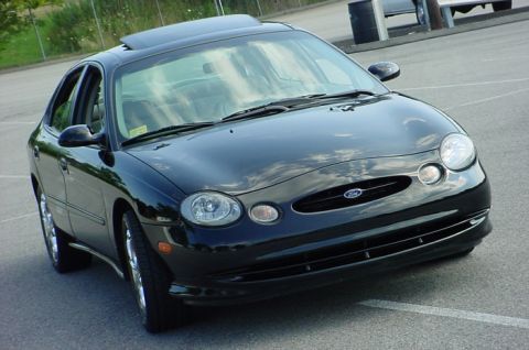 1998 Ford Taurus - This 1998 Ford Taurus is captured in a three-quarter front view, its black exterior and sunroof.