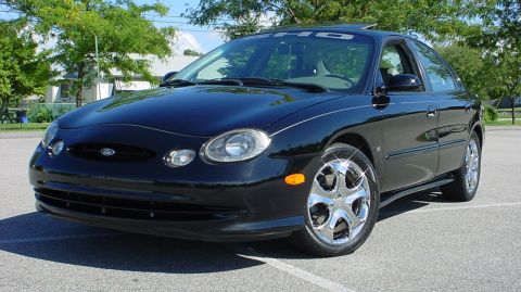 1998 Ford Taurus - A black 1998 Ford Taurus is shown from the front three-quarter view on a sunny day.