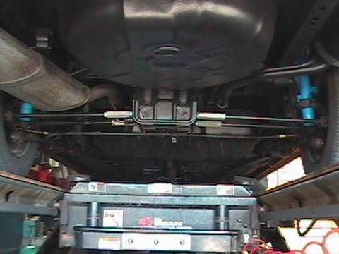 1995 Ford Taurus - Underbody view of a car on a lift, showing suspension and exhaust system components.