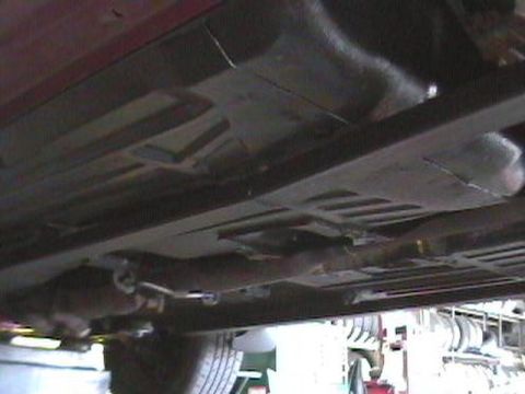 1995 Ford Taurus - The underside of a vehicle is visible, with various mechanical parts and exhaust systems.
