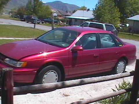 1995 Ford Taurus - This red 1995 Ford Taurus is parked outside on a sunny day.