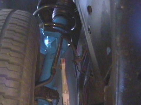 1995 Ford Taurus - Close-up view of a car's suspension system, showing the shock absorber and spring.