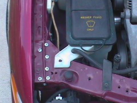 1995 Ford Taurus - Close-up of a car's engine bay, focusing on the washer fluid reservoir and surrounding components.