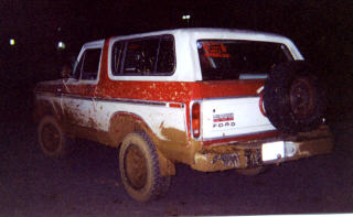 1978 Ford Bronco - 1978 Ford Bronco covered in mud after off-roading, seen from the rear.