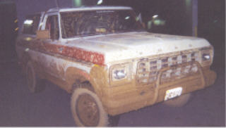 1978 Ford Bronco - This muddy Ford Bronco is seen from the front-right angle, appearing to be at a car wash.