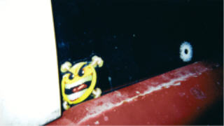 1978 Ford Bronco - A close-up of a cartoon sticker with a menacing expression applied to a vehicle's exterior.