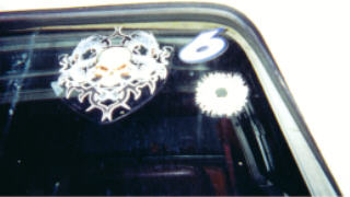 1978 Ford Bronco - Custom stickers adorn the rear window of a vehicle, including a skull emblem and a bullet hole graphic.