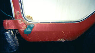 1978 Ford Bronco - This image shows the rusted corner of a red vehicle, possibly a truck or SUV.
