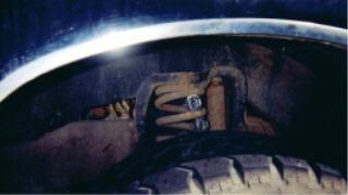 1990 Ford F-150 - Front suspension coil spring and shock assembly visible inside the wheel well.