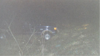 1990 Ford F-150 - A dark pickup truck is visible off-road at night, with its headlights on.