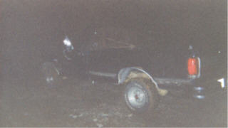 1990 Ford F-150 - A dark pickup truck is seen from the rear, with its trailer hitch visible.