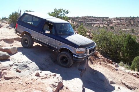 1994 Ford Bronco - This two-tone Ford Bronco is shown off-roading on a challenging rocky trail.