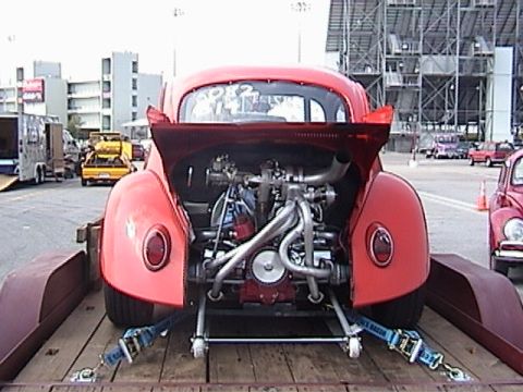 1998 Ford Taurus - A modified red Volkswagen Beetle is transported on a trailer, revealing its custom engine and racing setup.