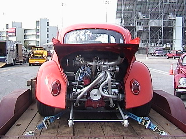 Red custom Volkswagen Beetle on a trailer, rear view, exposed engine, racing modifications
