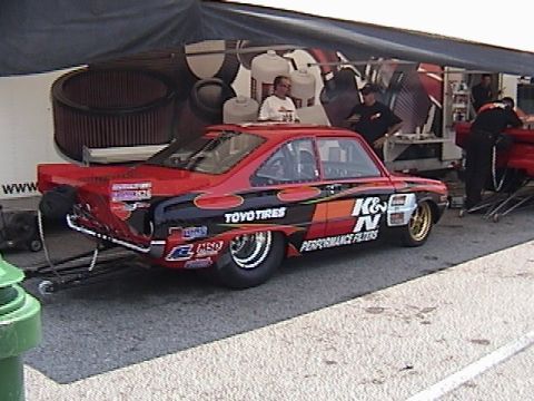1998 Ford Taurus - A custom drag car, likely from a race event, displays prominent sponsor decals on its side.