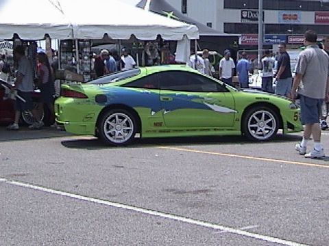 1998 Ford Taurus - Side view of a modified sports car with distinctive green and blue graphics. The car appears to be at an outdoor event.