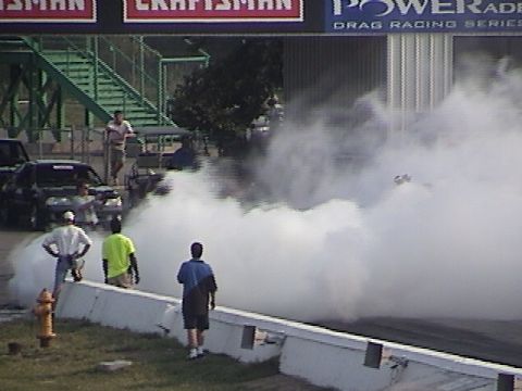 1998 Ford Taurus - A car performs a burnout at a drag racing event, creating a large cloud of smoke.