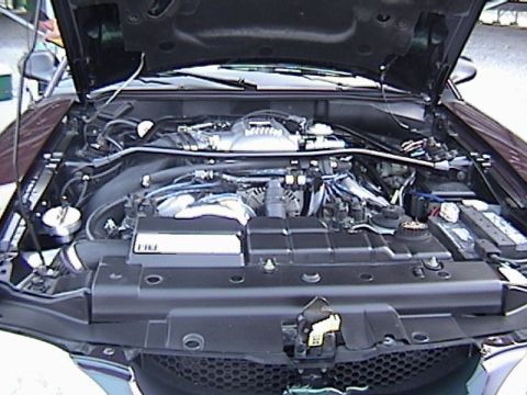 1998 Ford Taurus - The engine bay of a vehicle is shown, a V8 engine and a watermark for Supermotors.net.