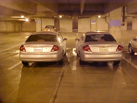 2001 Ford Taurus - Two silver sedans are parked in a garage, with one slightly ahead of the other.