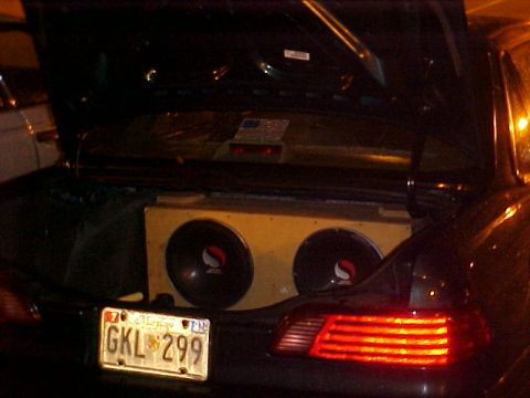 2001 Ford Taurus - The trunk of a car is open, revealing a large subwoofer box with two speakers and a license plate reading GKL 299.