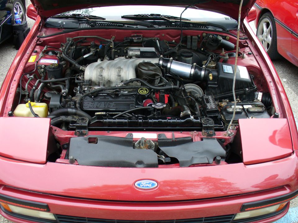 Red Ford engine bay showing 3.0 V6 with aftermarket cone intake