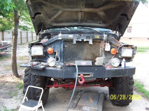 1978 Ford Bronco - The front of a truck is shown with the hood up and the grille removed, revealing the radiator and engine components.