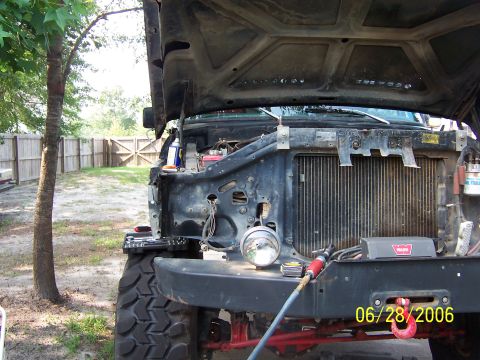 1978 Ford Bronco - The front of a 1978 Ford Bronco is visible with the hood open, revealing the engine bay and radiator.