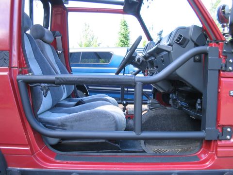 1987 Suzuki Samurai - Interior view of a red Suzuki Samurai, showing the seats, dashboard, and roll cage.