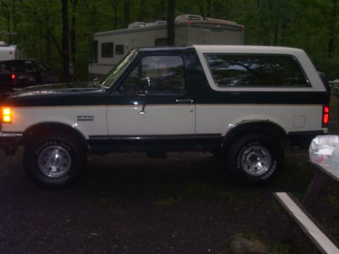 1991 Ford Bronco - This 1991 Ford Bronco is shown in a side profile, with a dark green top and trim contrasting with its white body.