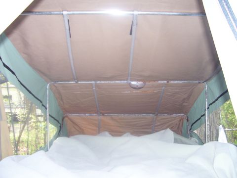 1991 Ford Bronco - Interior of a pop-up camper tent showing the metal frame and tan fabric walls.