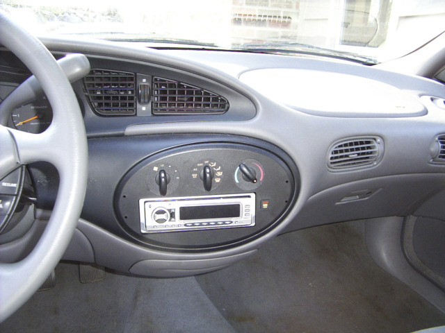 Gray Mercury sedan dashboard with oval HVAC controls and aftermarket radio