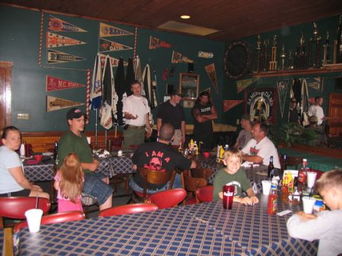 1995 Ford Bronco - A group of people are gathered in a room adorned with sports memorabilia and trophies.