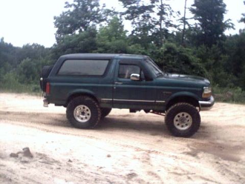1996 Ford Bronco - Green 1996 Ford Bronco with lifted suspension on a dirt path.