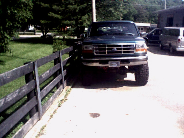 Green Ford F-Series truck with lifted suspension, front view